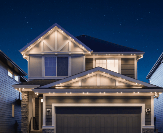 Two-story home with warm white Gemstone Lights outlining the roofline and gables, creating a clean, architectural look against a night sky.