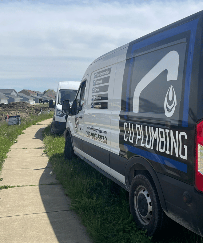 C-U Plumbing service van parked along a residential construction site in Central Illinois, showing company branding and contact information for plumbing, remodeling, and new construction services.