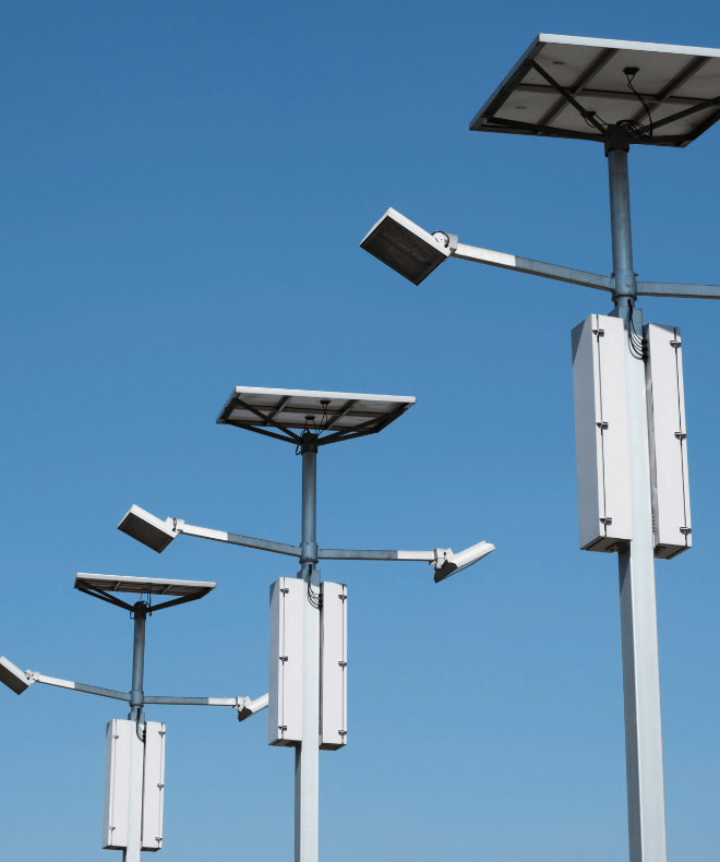 Solar-powered LED parking lot light poles installed for commercial site lighting under a clear sky.