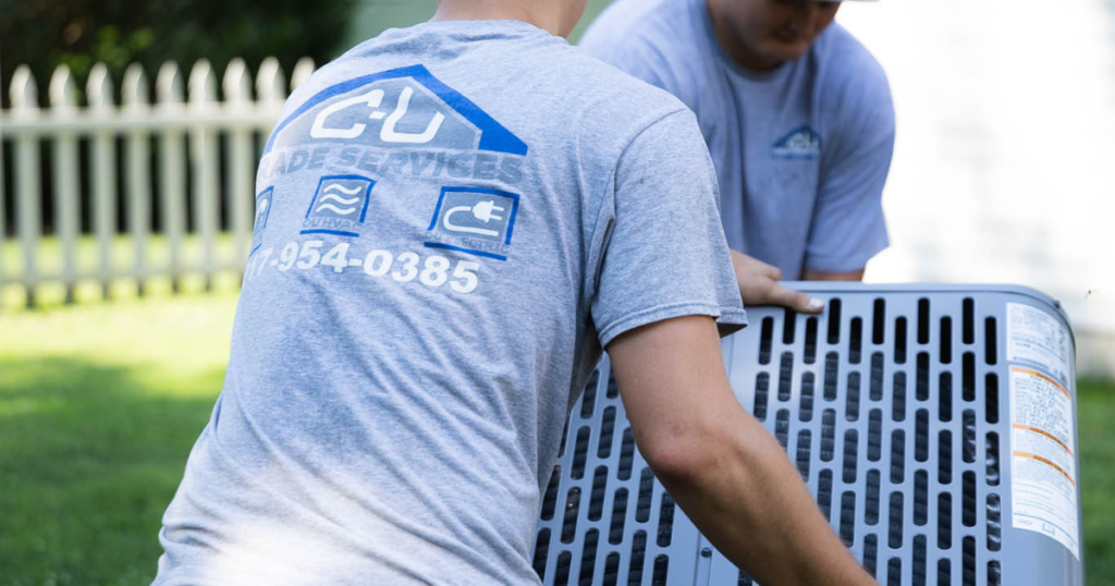 C-U Trade Services technicians removing an outdoor air conditioner unit during HVAC replacement in Central Illinois